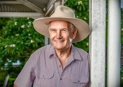 man leaning on verandah wearing an akubra