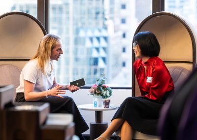 two woman sitting networking in conference
